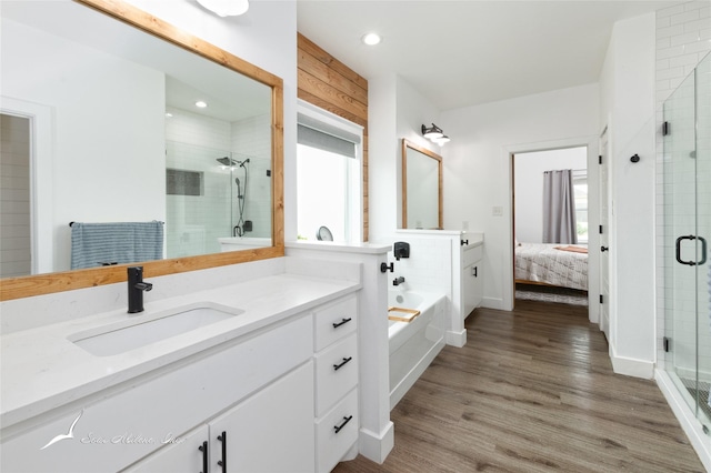 ensuite bathroom with vanity, recessed lighting, wood finished floors, ensuite bathroom, and a stall shower