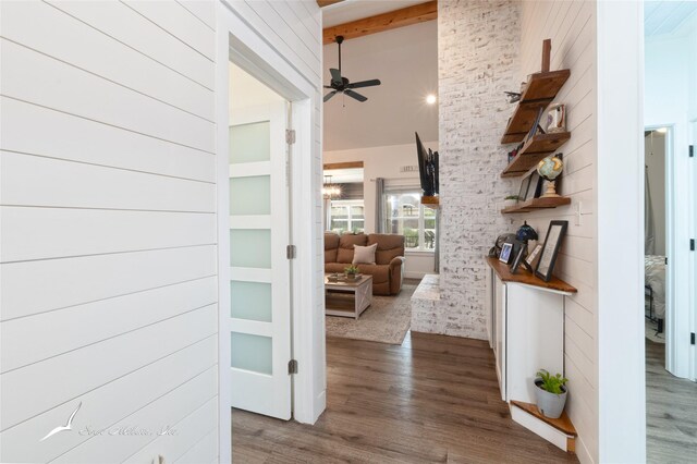 hall featuring high vaulted ceiling, beam ceiling, and wood finished floors
