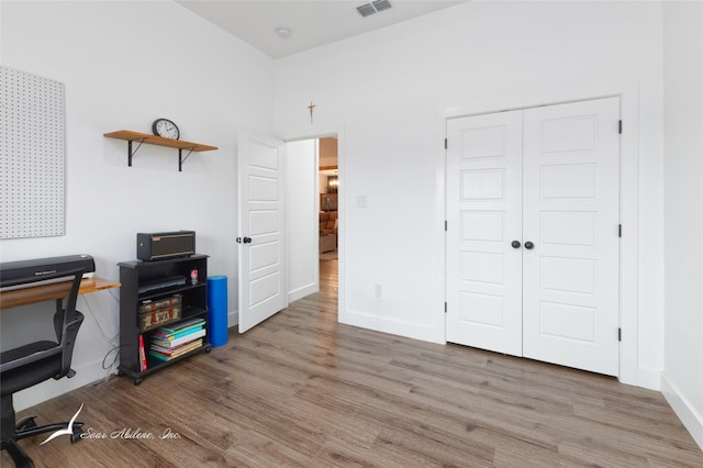 office area with baseboards, wood finished floors, and visible vents