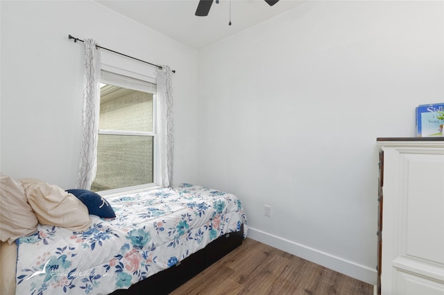 bedroom featuring a ceiling fan, baseboards, and wood finished floors