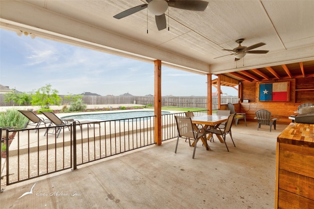 view of patio featuring ceiling fan, a fenced in pool, a fenced backyard, and outdoor dining space