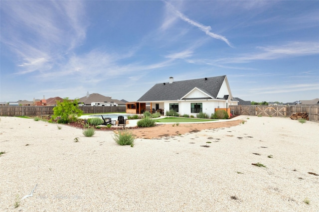 back of house featuring roof with shingles, a fenced in pool, a fenced backyard, and a patio area