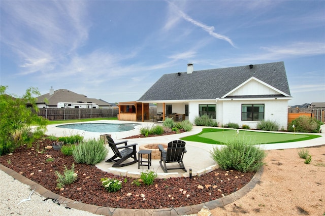 back of house featuring a patio, a fenced in pool, a shingled roof, and a fenced backyard