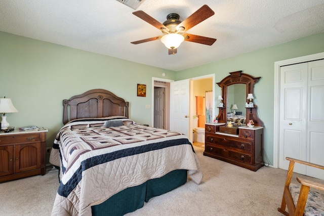 bedroom with a ceiling fan, light carpet, a closet, and ensuite bath