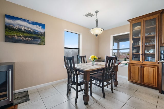 dining area featuring baseboards, a wealth of natural light, light tile patterned flooring, and visible vents