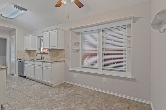 kitchen with white cabinets, a sink, a ceiling fan, backsplash, and stainless steel dishwasher