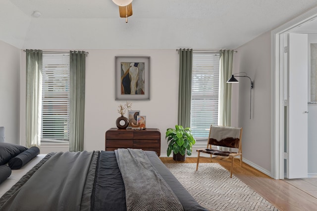 bedroom with light wood-type flooring, baseboards, and multiple windows