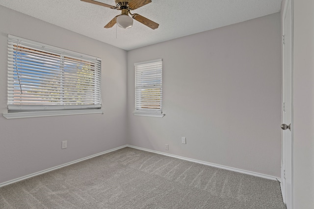 empty room with carpet floors, baseboards, a ceiling fan, and a textured ceiling
