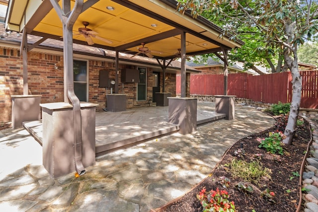 view of patio featuring ceiling fan and fence