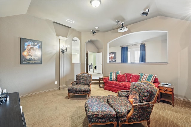 carpeted living room with arched walkways, baseboards, visible vents, and lofted ceiling