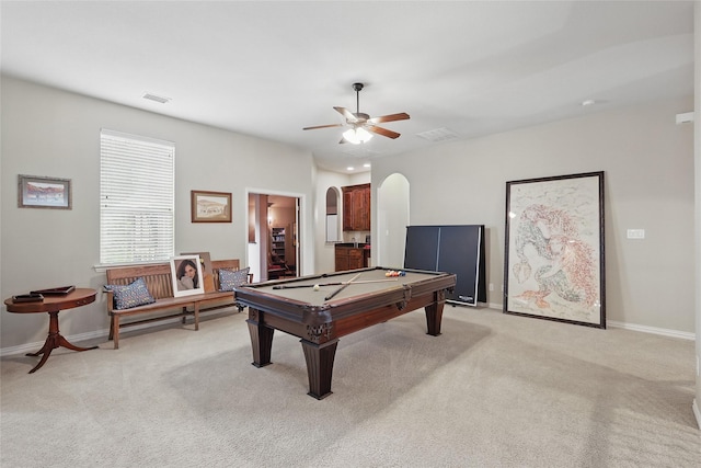playroom featuring baseboards, arched walkways, and light carpet