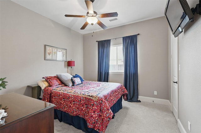 bedroom featuring visible vents, baseboards, ceiling fan, and light carpet