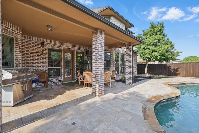 view of patio with fence, a fenced in pool, outdoor dining area, and grilling area