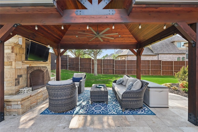 view of patio featuring a gazebo, a fenced backyard, and an outdoor living space with a fireplace