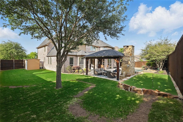 back of house featuring a fenced backyard, an outdoor hangout area, brick siding, a patio area, and a gazebo
