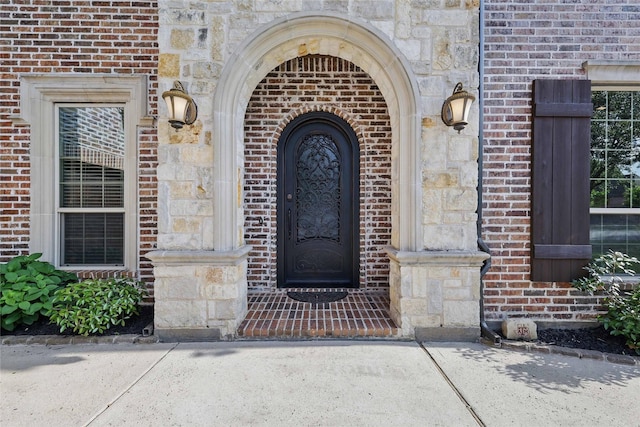 property entrance with brick siding and stone siding