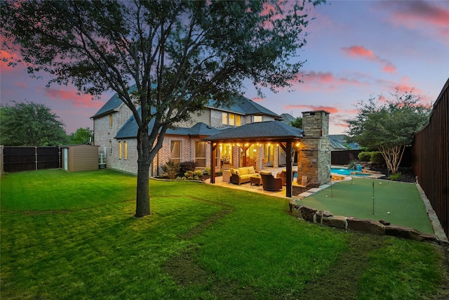 rear view of property with an outdoor hangout area, a shed, a fenced backyard, an outbuilding, and a chimney