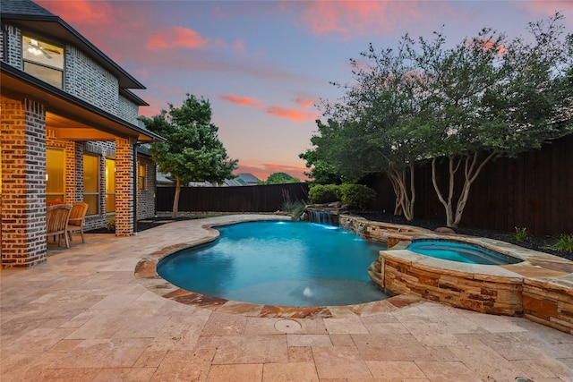 view of pool with a pool with connected hot tub, a fenced backyard, and a patio area