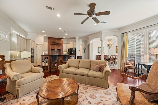 living area featuring a ceiling fan, ornamental molding, wood finished floors, recessed lighting, and arched walkways