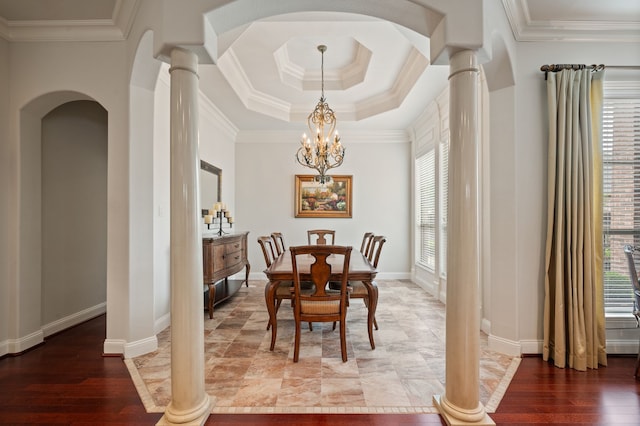 dining room featuring a notable chandelier, arched walkways, ornate columns, a tray ceiling, and ornamental molding