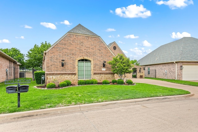 view of front of property featuring concrete driveway, brick siding, fence, and a front yard