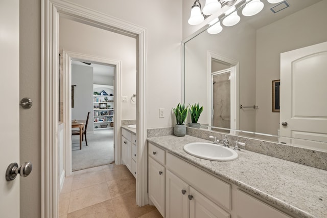 full bath featuring a shower with door, visible vents, tile patterned floors, and vanity