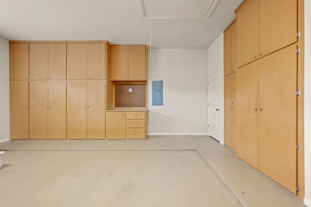 unfurnished bedroom with a closet, concrete flooring, baseboards, attic access, and electric panel