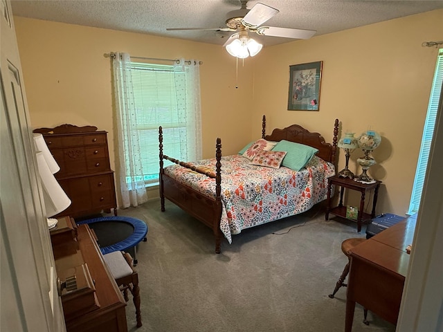 carpeted bedroom with ceiling fan and a textured ceiling