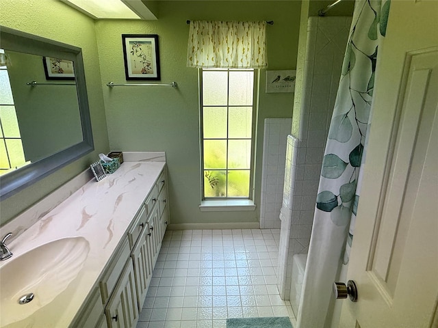 full bathroom featuring tile patterned floors, baseboards, shower / tub combo with curtain, and vanity