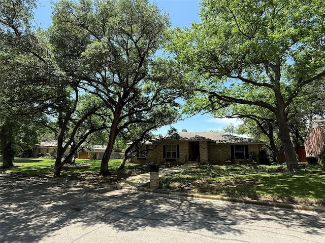 view of front of house with a chimney and a front yard