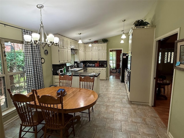dining room featuring vaulted ceiling and a chandelier