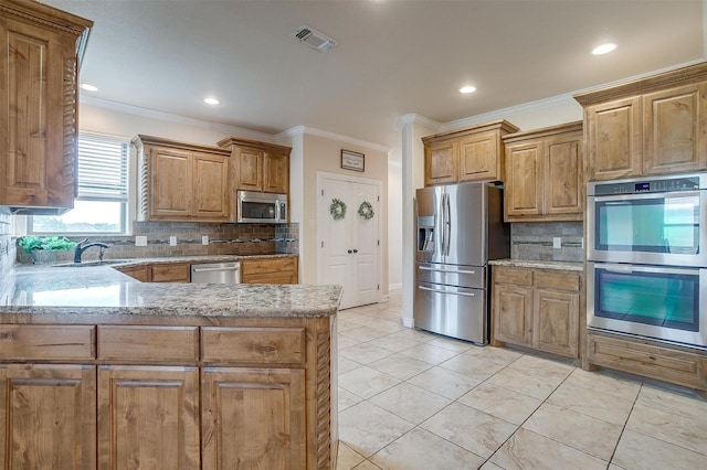 kitchen featuring backsplash, crown molding, appliances with stainless steel finishes, light stone countertops, and a sink