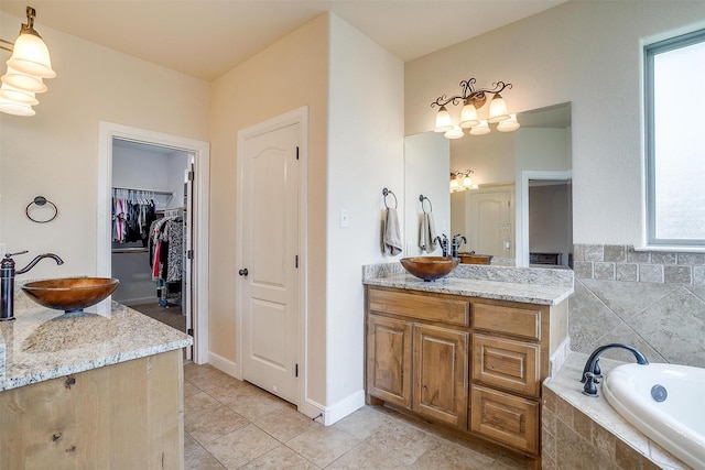 bathroom featuring a sink, tile patterned floors, a garden tub, and two vanities