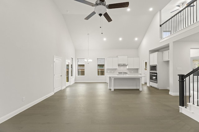 4327 Hudson St, Fate, TX 75087 - unfurnished living room featuring high vaulted ceiling, a ceiling fan, stairway, a chandelier, and dark wood-style flooring