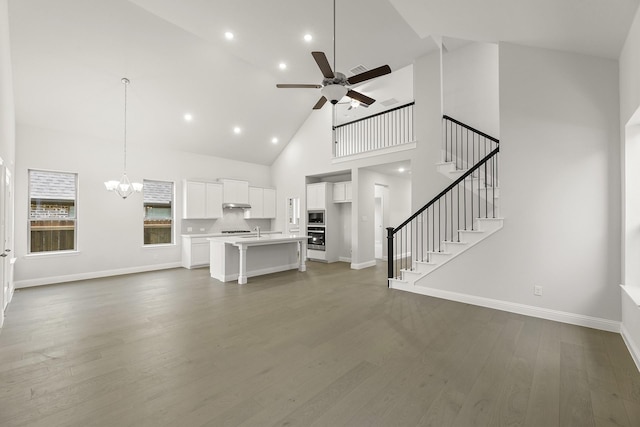 4327 Hudson St, Fate, TX 75087 - unfurnished living room with high vaulted ceiling, a ceiling fan, a chandelier, baseboards, and dark wood-type flooring