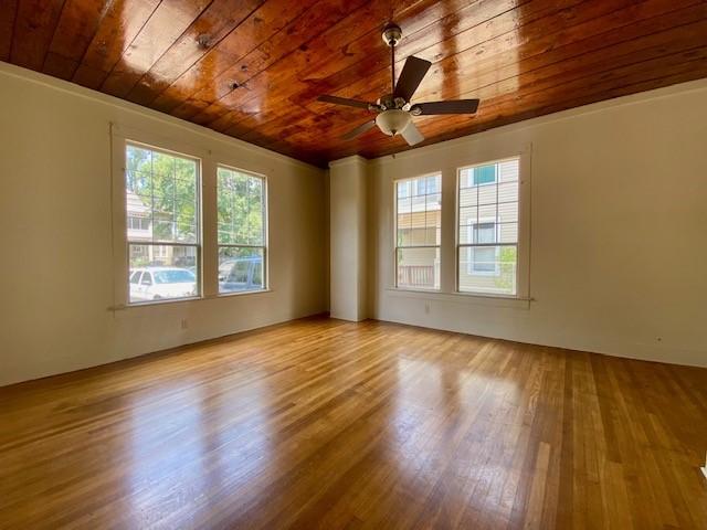 spare room with ceiling fan, wood finished floors, and wooden ceiling