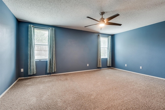 carpeted spare room featuring a ceiling fan, a textured ceiling, and baseboards