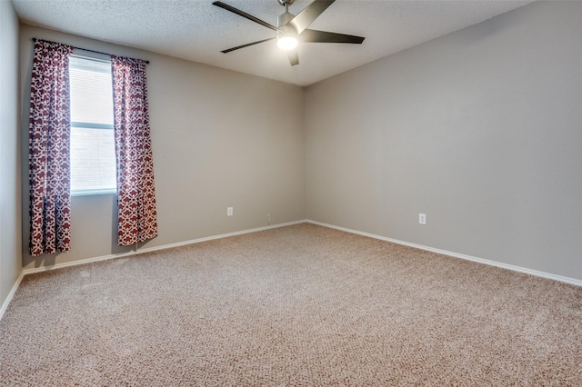 carpeted empty room featuring baseboards, ceiling fan, and a textured ceiling