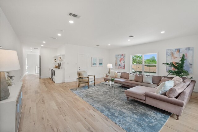 living room with visible vents, recessed lighting, and light wood-type flooring