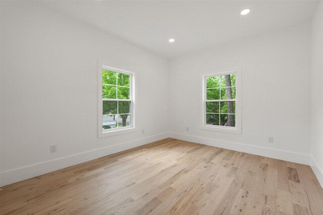 empty room featuring recessed lighting, baseboards, and wood finished floors