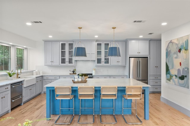 kitchen featuring a sink, gray cabinetry, stainless steel appliances, and visible vents