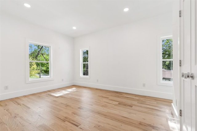 spare room featuring baseboards, recessed lighting, and a wealth of natural light