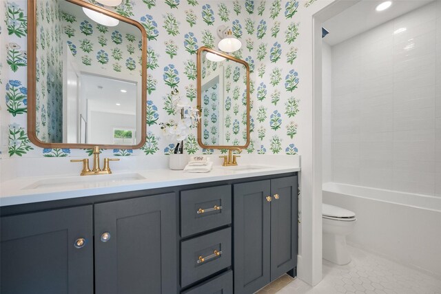 bathroom with a sink, toilet, and wallpapered walls