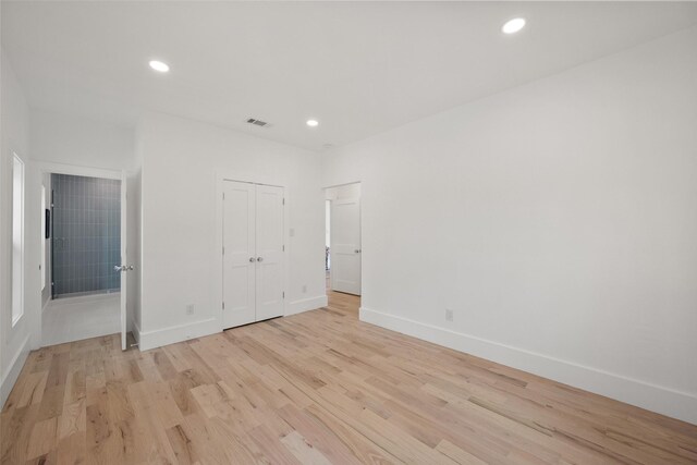 unfurnished bedroom with baseboards, a closet, recessed lighting, and light wood-style flooring