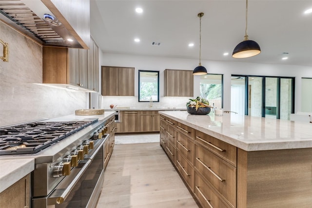 kitchen featuring range with two ovens, range hood, tasteful backsplash, a spacious island, and recessed lighting