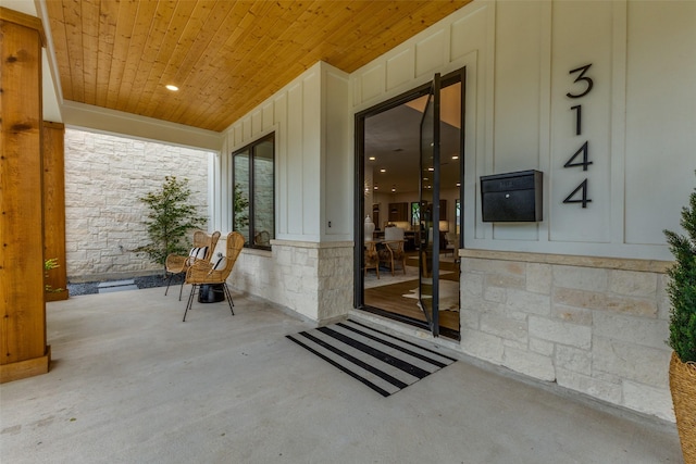 view of exterior entry featuring a porch and stone siding