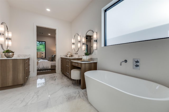 ensuite bathroom with ensuite bath, a freestanding tub, vanity, marble finish floor, and recessed lighting