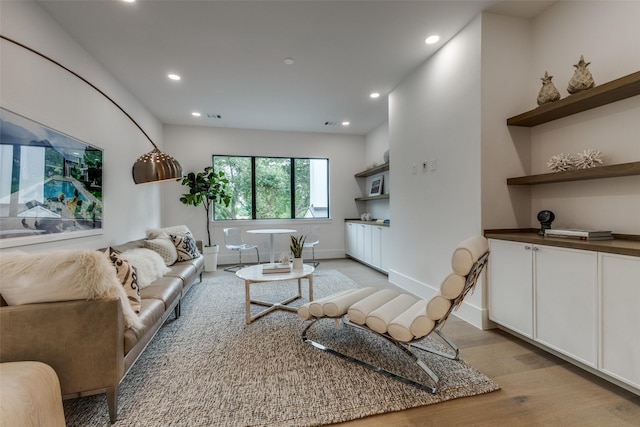 living area featuring recessed lighting, baseboards, visible vents, and light wood-style floors