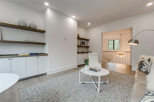 living room featuring light wood-style floors, baseboards, an inviting chandelier, and recessed lighting