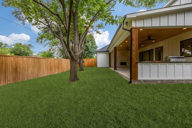 view of yard featuring fence, a ceiling fan, a patio area, and area for grilling